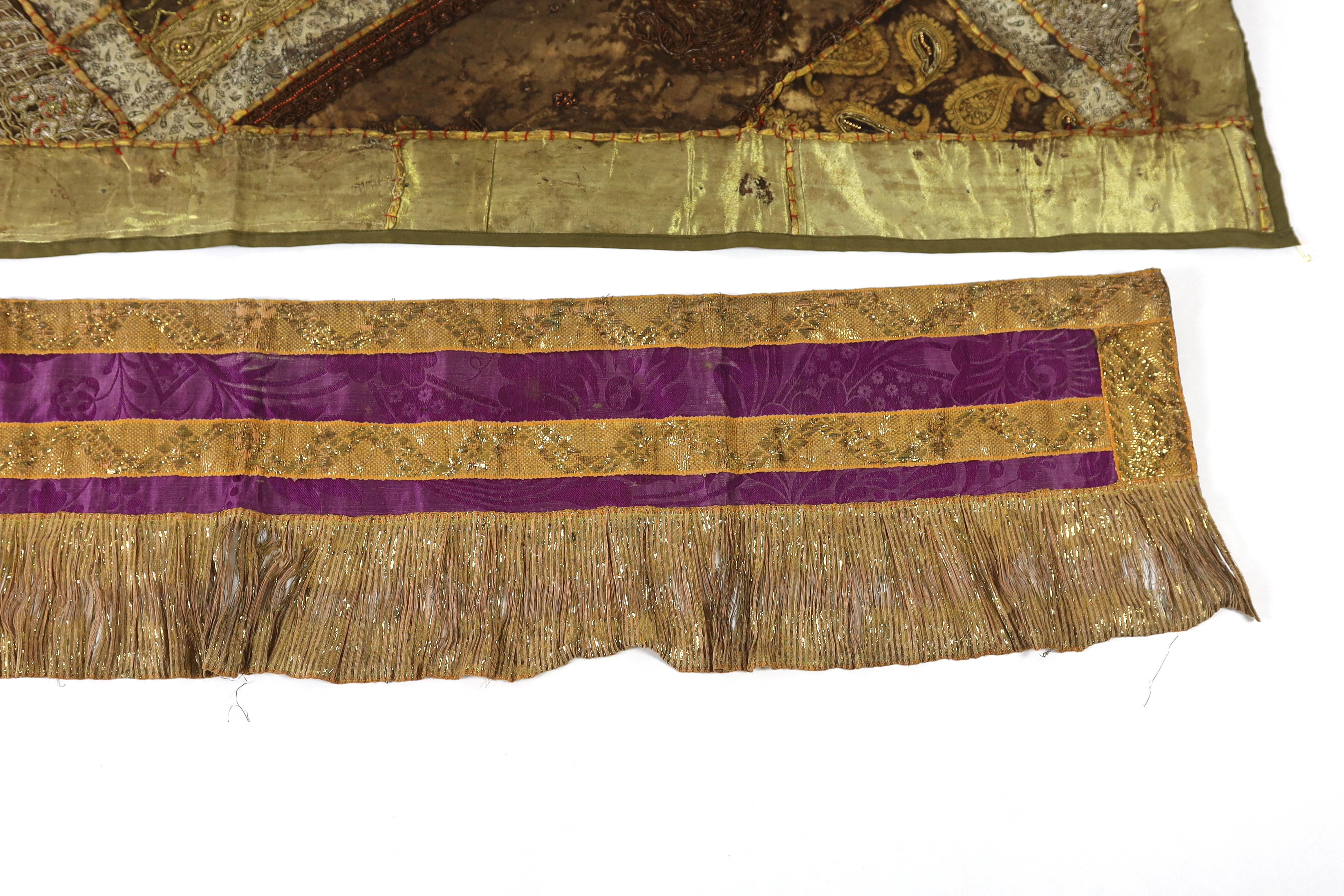 A 20th century Indian patchwork hanging, designed in golds and browns using patchwork batik, beadwork and metallic embroidery, each bordered with thick silk strands bound together, the hanging then bordered with gold met